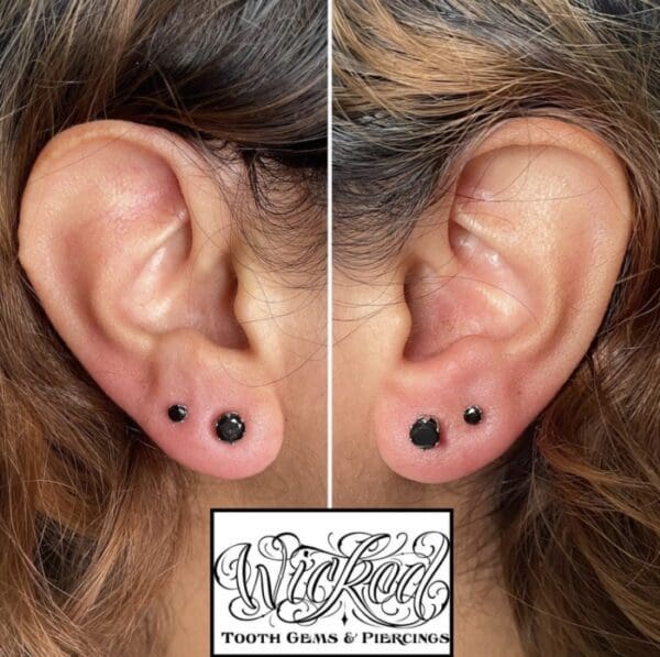 A woman with two different ear piercings and one is wearing black.