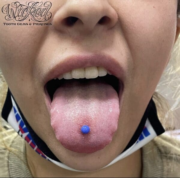 A woman with blue pill in her mouth.