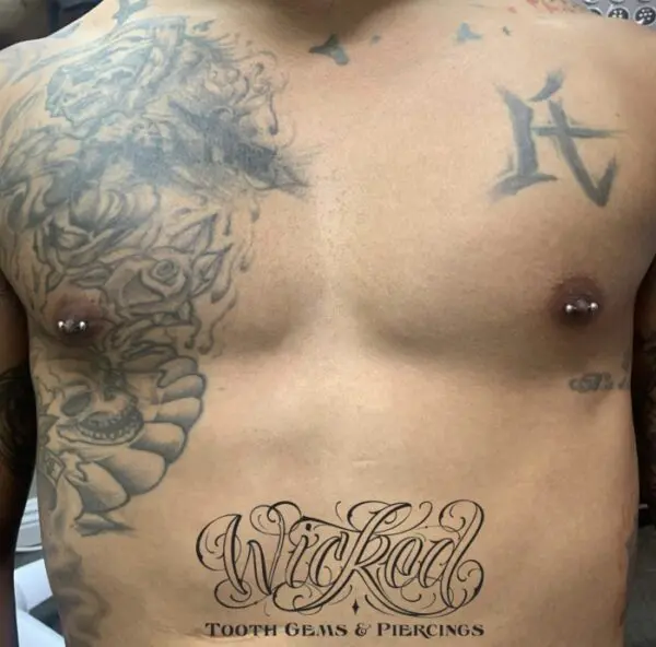 A man with tattoos on his chest and stomach.