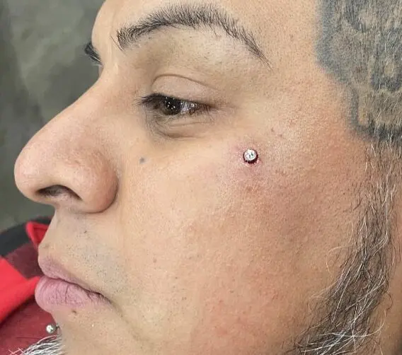 A woman with tattoos and piercing on her nose.