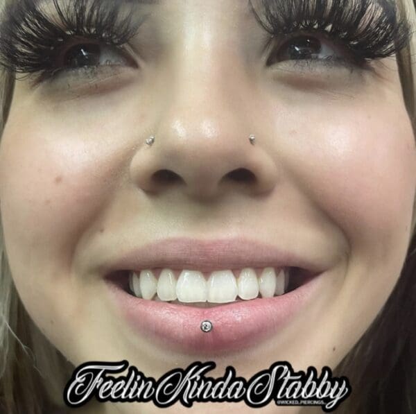 A woman with fake lashes and white teeth.