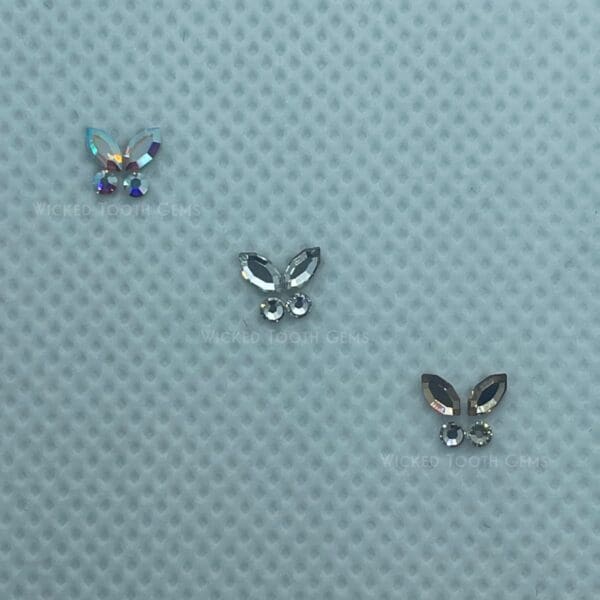 Three butterflies are sitting on a blue surface.