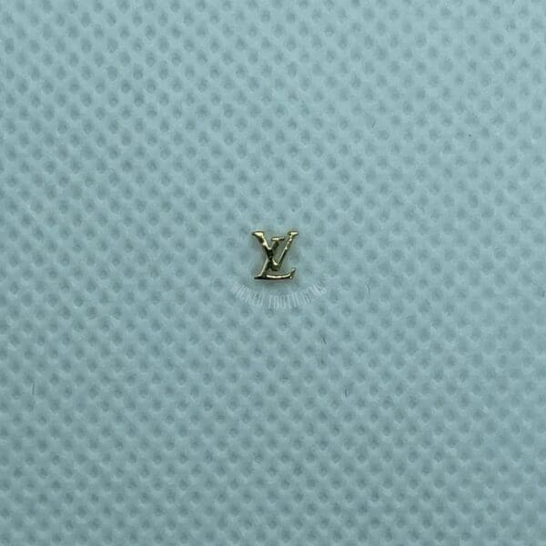 A small gold letter sitting on top of a blue surface.