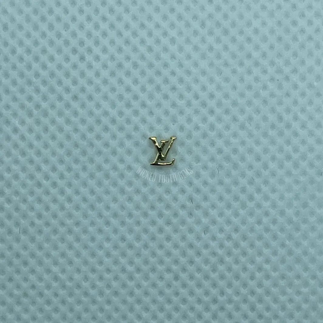 A small gold letter sitting on top of a blue surface.