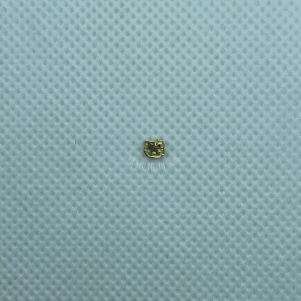 A small piece of gold sitting on top of a blue surface.