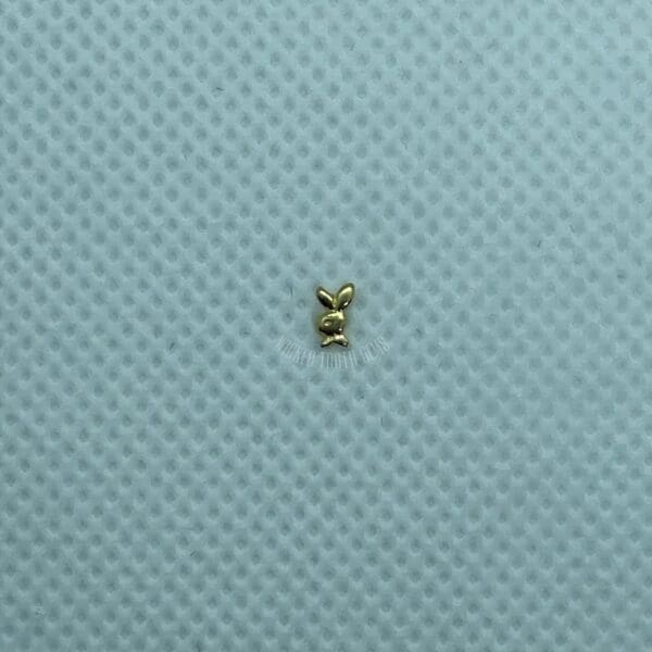 A small gold object sitting on top of a blue surface.