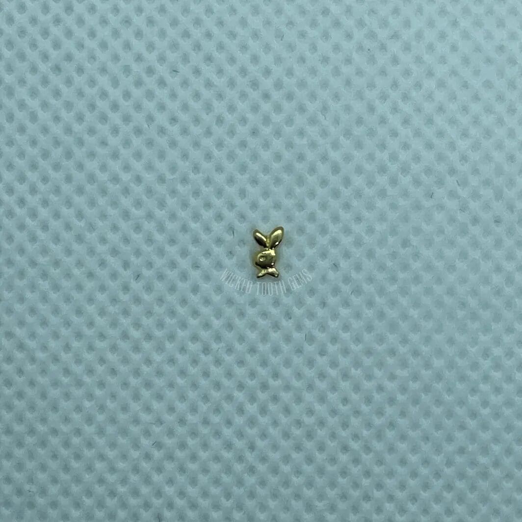 A small gold object sitting on top of a blue surface.