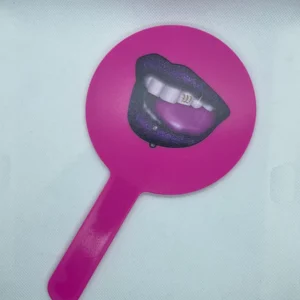 A pink hand mirror with a picture of lips on it.