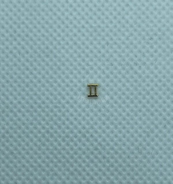 A small piece of metal sitting on top of a blue surface.