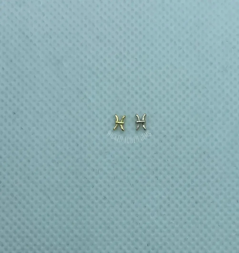 A pair of earrings sitting on top of a blue surface.