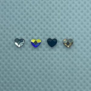 Four different colored hearts are sitting on a blue surface.