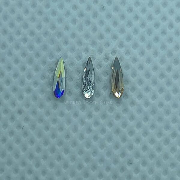 Three different colored crystals on a blue surface.