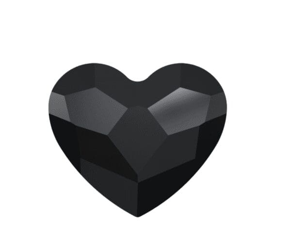 A black heart shaped stone sitting on top of a white table.