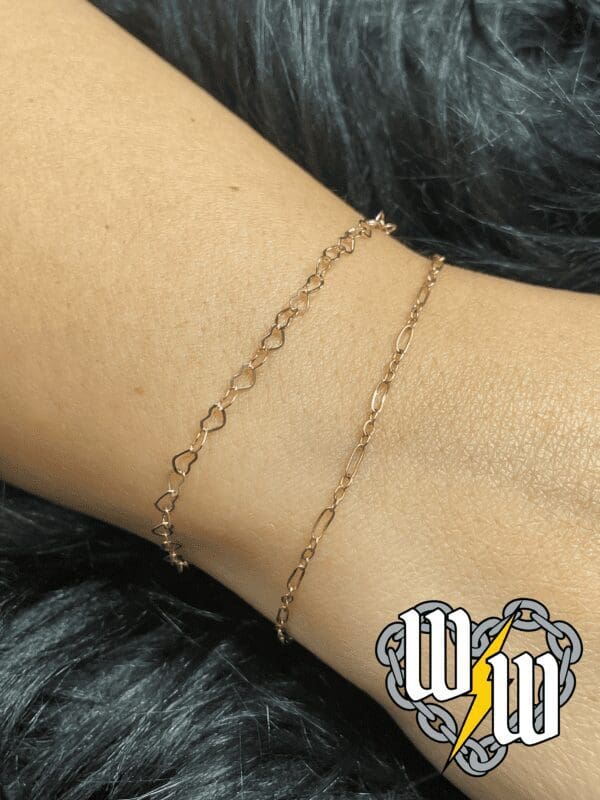 A woman wearing a gold chain bracelet on her wrist.