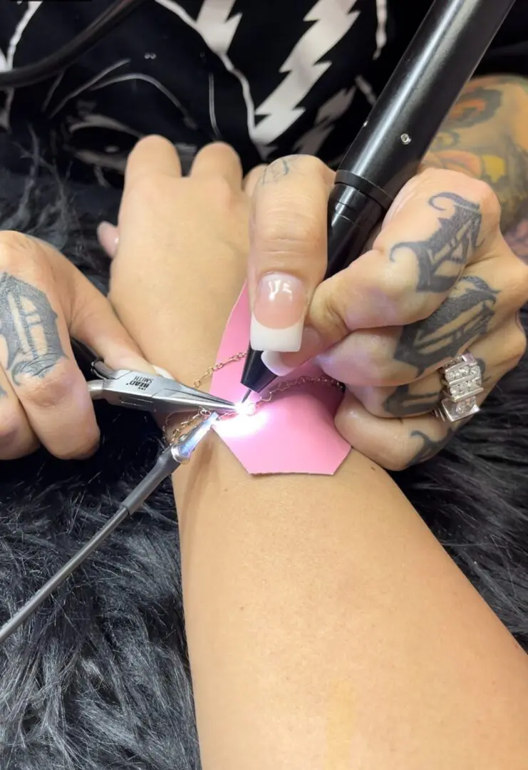 A person is using scissors to cut off the pink strip.