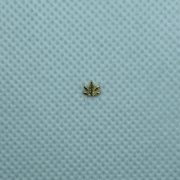 A small leaf is sitting on the surface of a blue cloth.