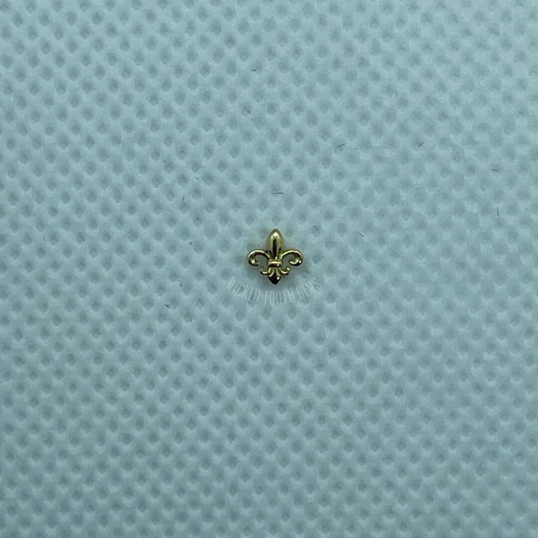 A small gold object sitting on top of a blue surface.