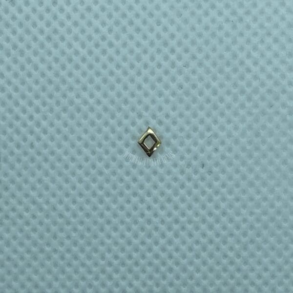 A small diamond is sitting on top of a blue surface.