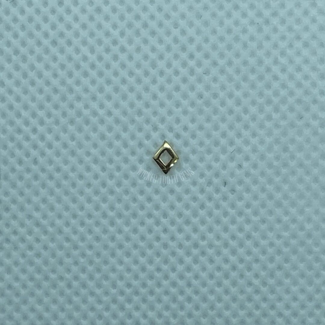 A small diamond is sitting on top of a blue surface.