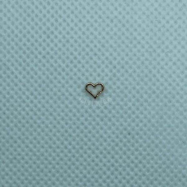 A heart shaped piece of metal on top of a blue cloth.