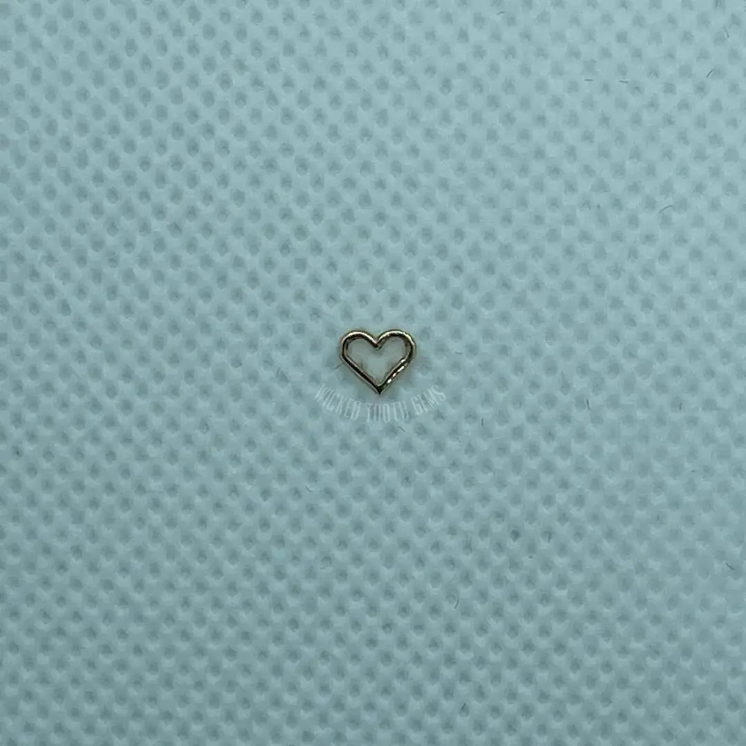 A heart shaped piece of metal on top of a blue cloth.