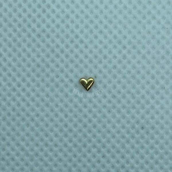 A gold heart is sitting on the surface.