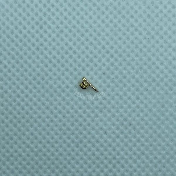 A tiny key is sitting on the surface of a blue cloth.