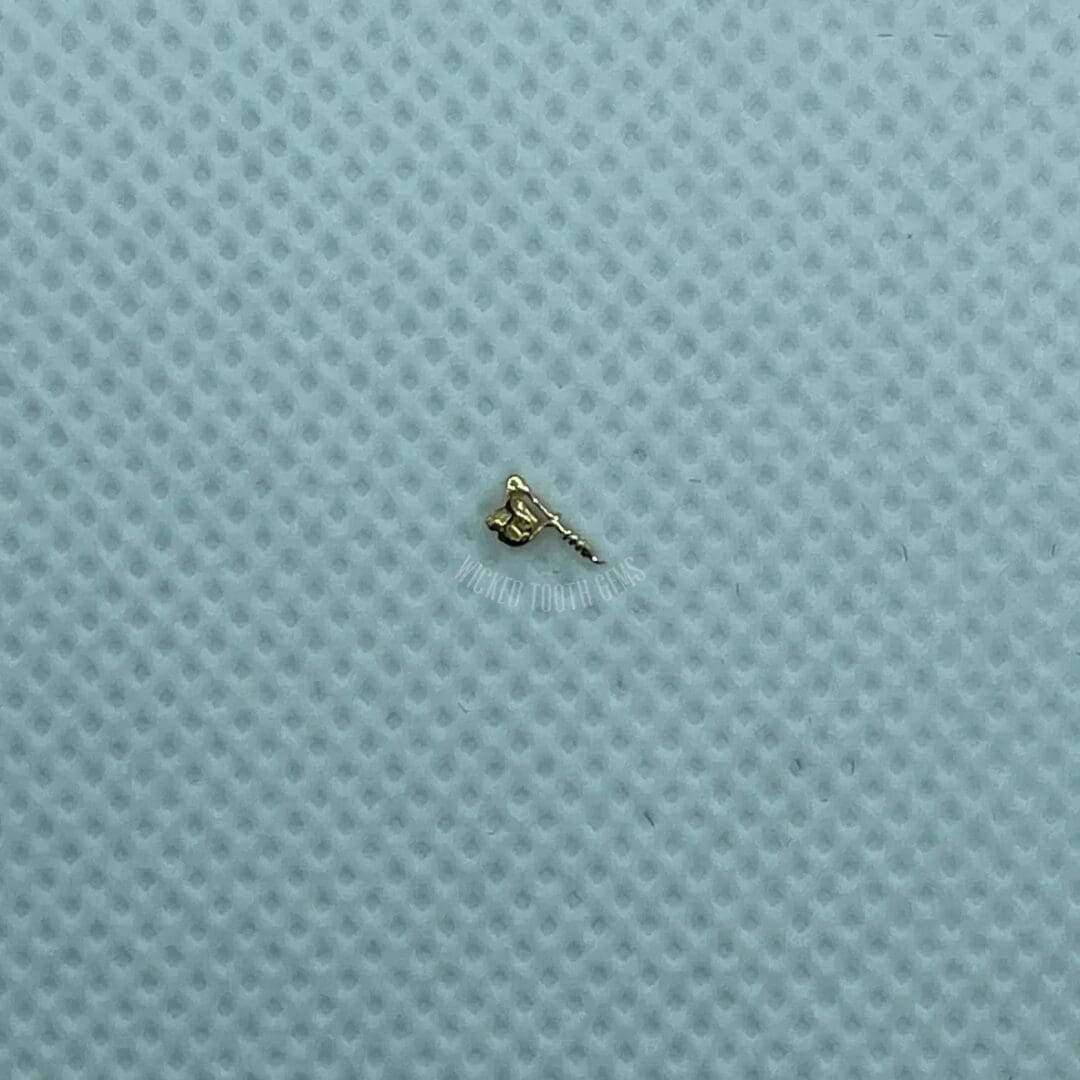 A tiny key is sitting on the surface of a blue cloth.