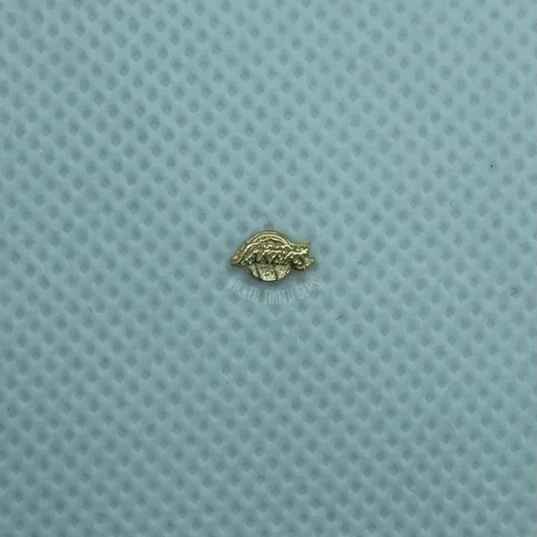 A small gold object sitting on top of a blue surface.