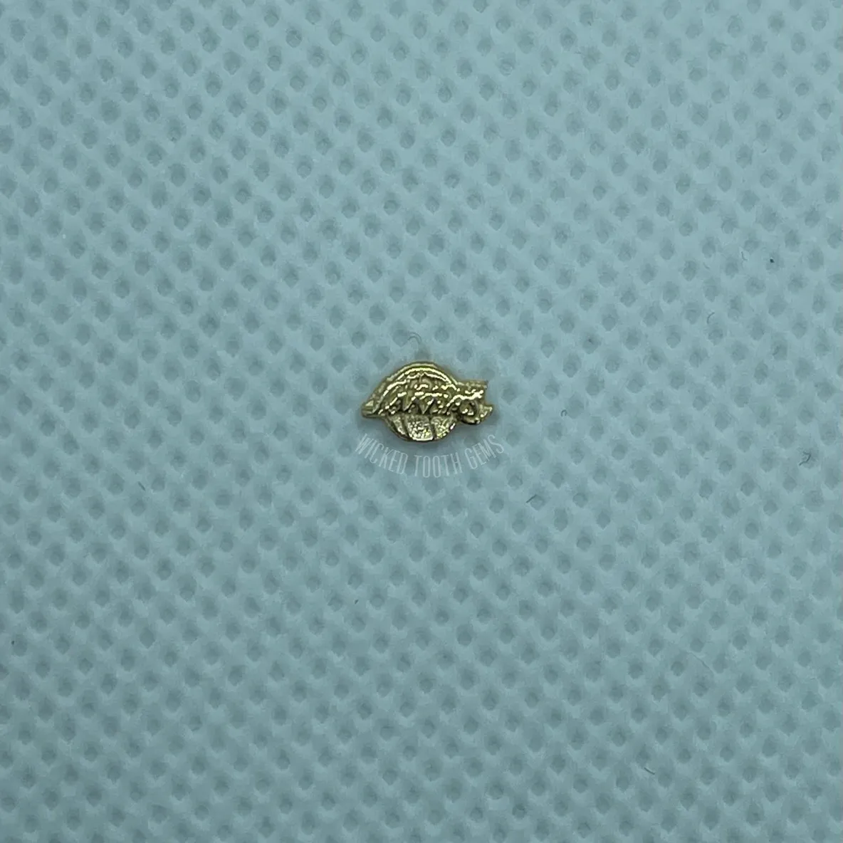 A small gold object sitting on top of a blue surface.