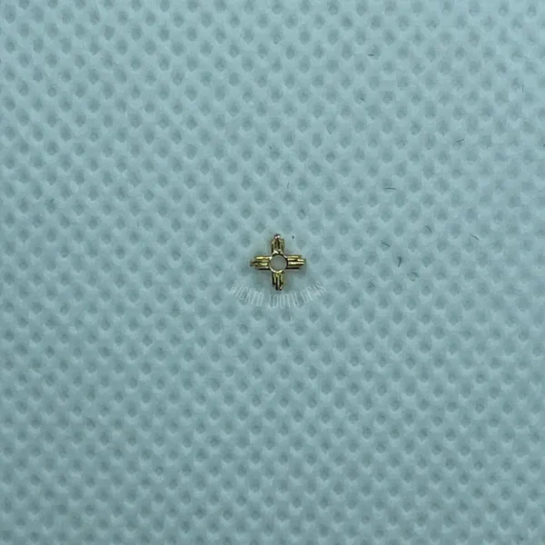 A small gold cross on top of a blue surface.