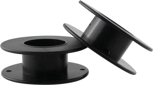 A pair of black plastic spools with one spool missing.