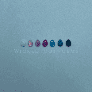 A row of different colored nail polish on top of a blue surface.