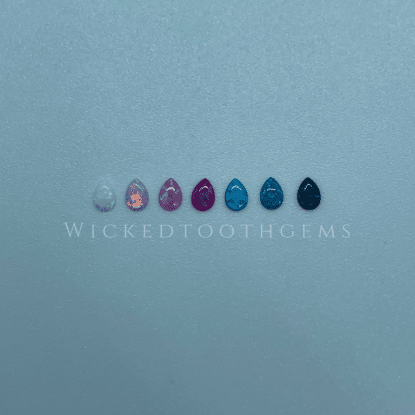 A row of different colored nail polish on top of a blue surface.