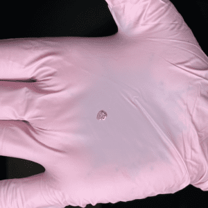 A hand with pink gloves and a white glove.
