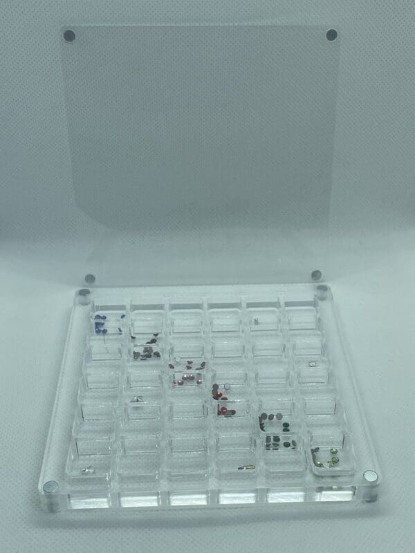 A clear plastic case with many different types of small objects.