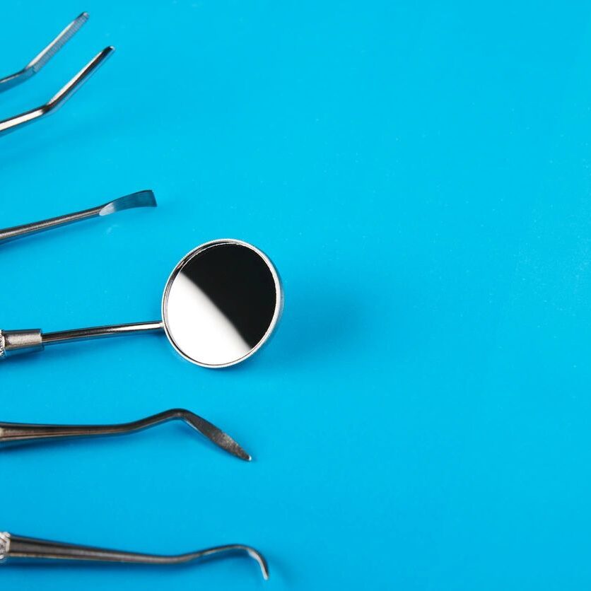 A group of dental instruments on top of a blue table.